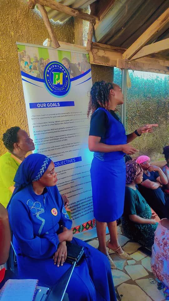 A PhiphyMak team member with mothers beside the organisation banner