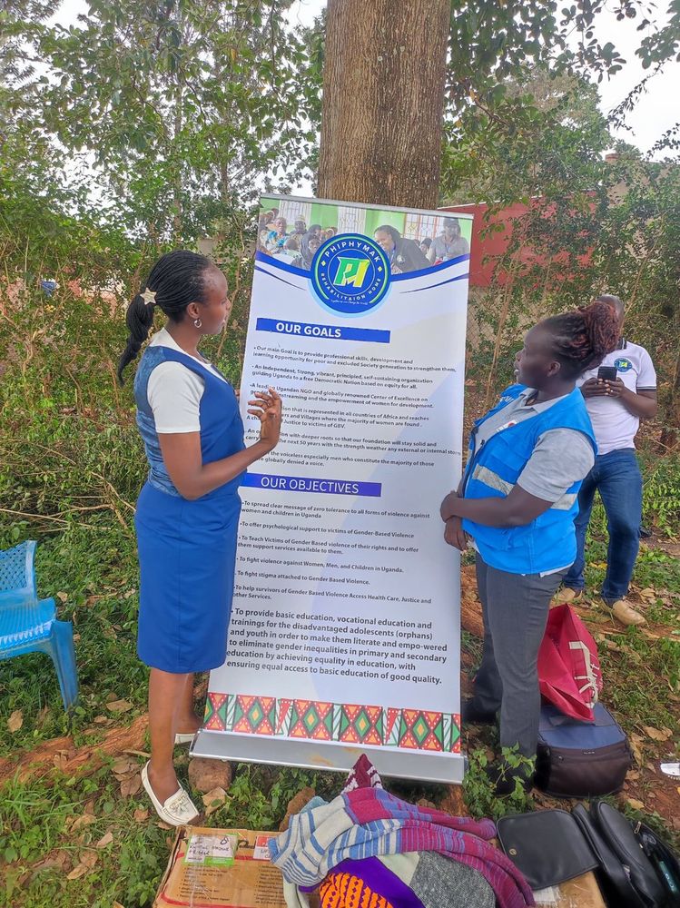 Two team members setting up the organisation banner at the outreach ground