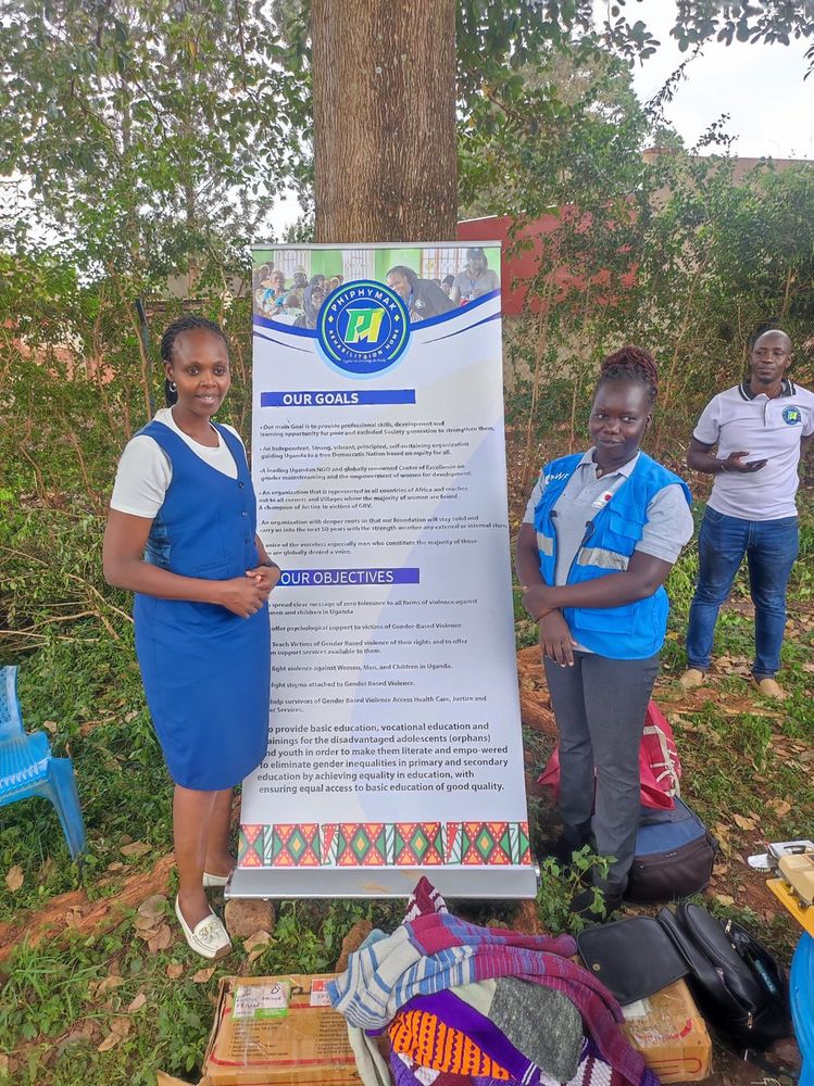 A team member and a partner volunteer standing beside the banner