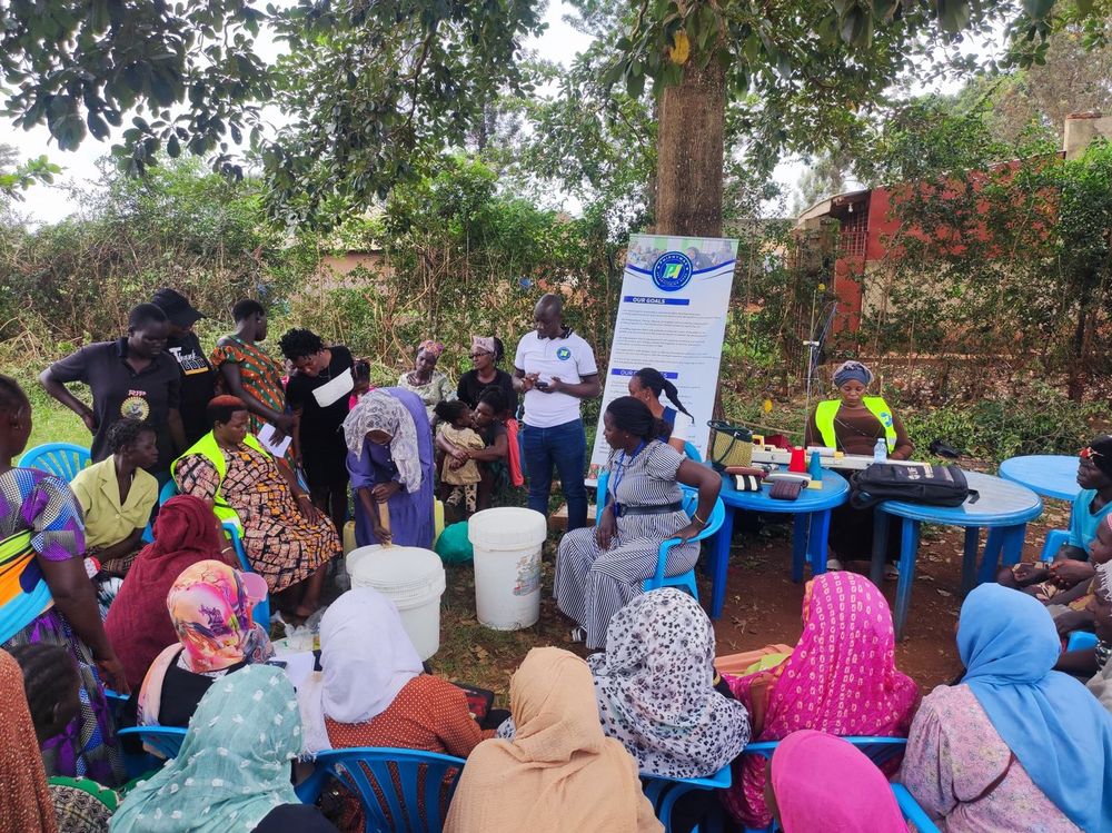 A large group of women seated under the trees during the session