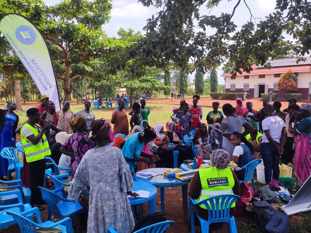 Participants seated on blue chairs around the tables of supplies