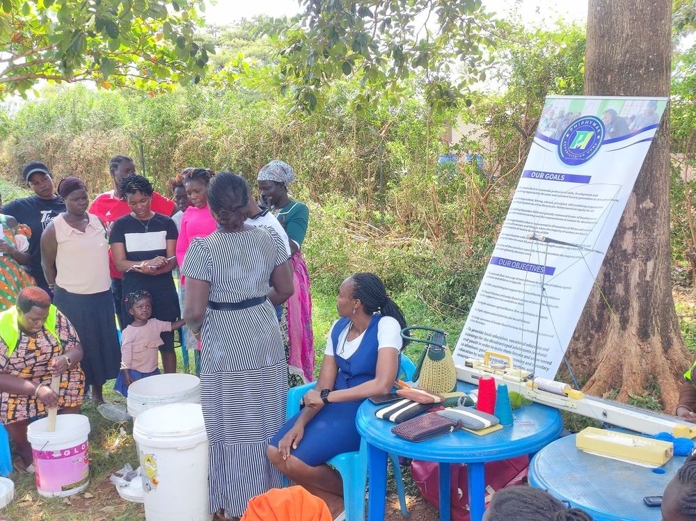 A team member speaking with a small group beside the banner