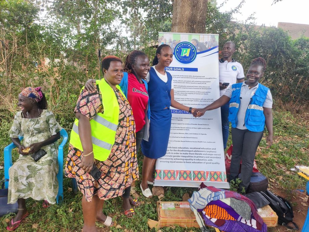 Team members and a participant standing beside the banner