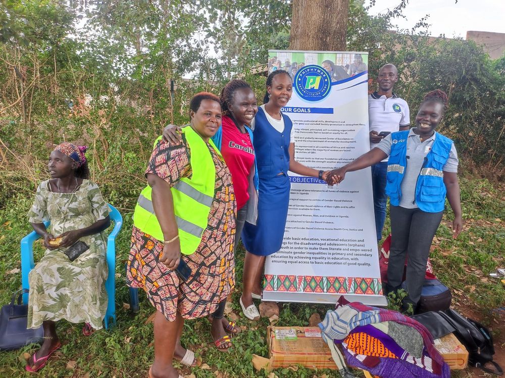 Staff and volunteers with participants beside the organisation banner