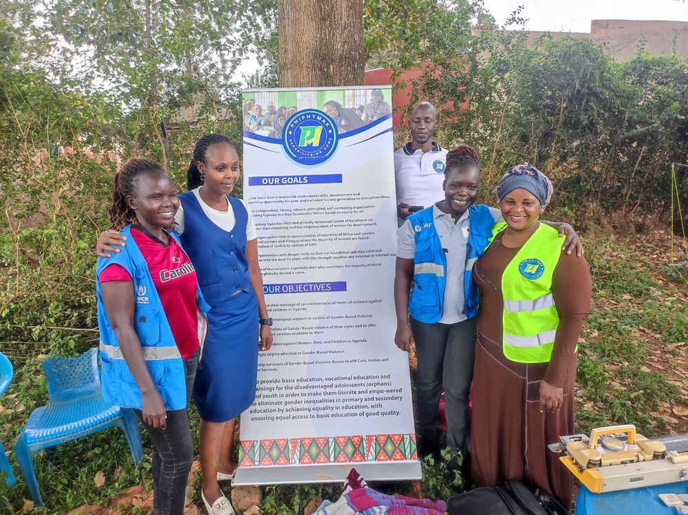 Team members and volunteers gathered beside the banner