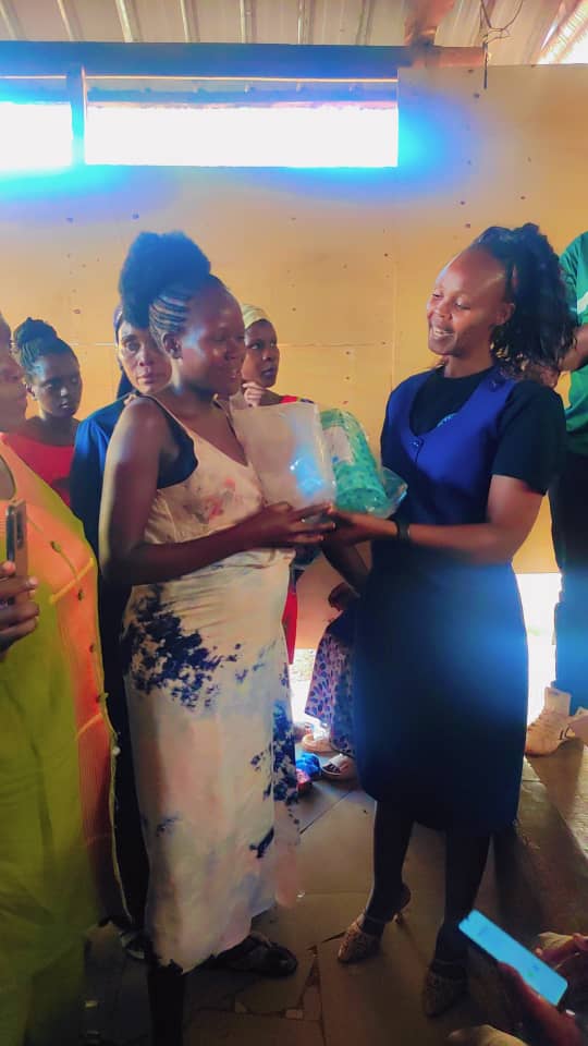 A team member handing a package to a mother during the distribution