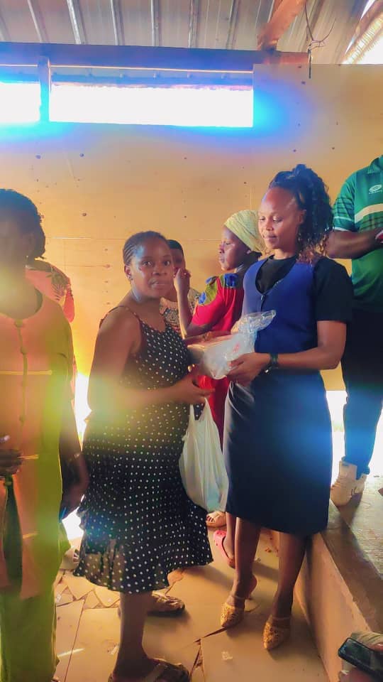 A team member passing supplies to a mother in the queue