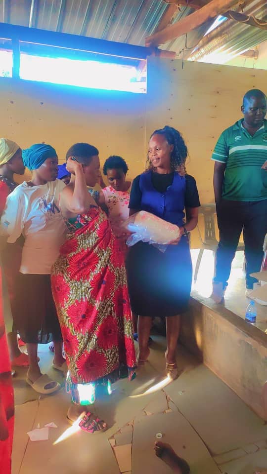 A team member handing supplies to a mother as others wait