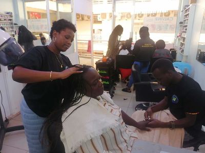 A PhiphyMak trainee practising hairdressing in a working salon