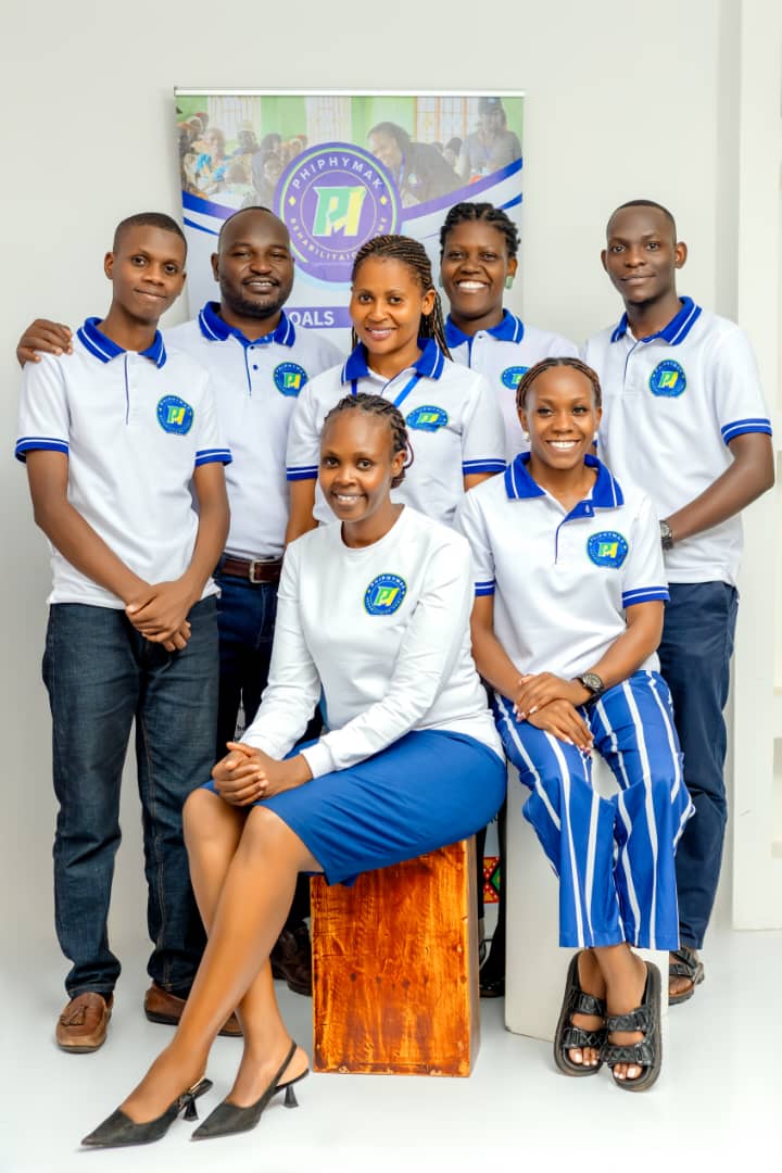 The team of PhiphyMak Rehabilitation Home Uganda in branded shirts, photographed together in front of the organisation banner